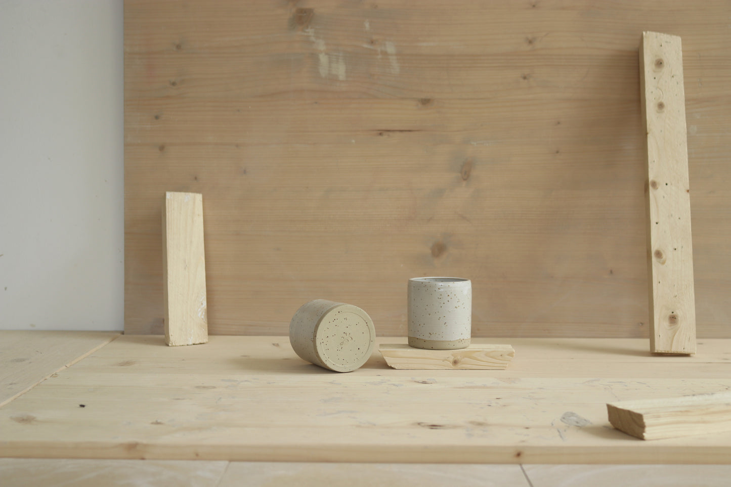 Handmade speckled stoneware narrow-shaped sip cups covered in white glaze.